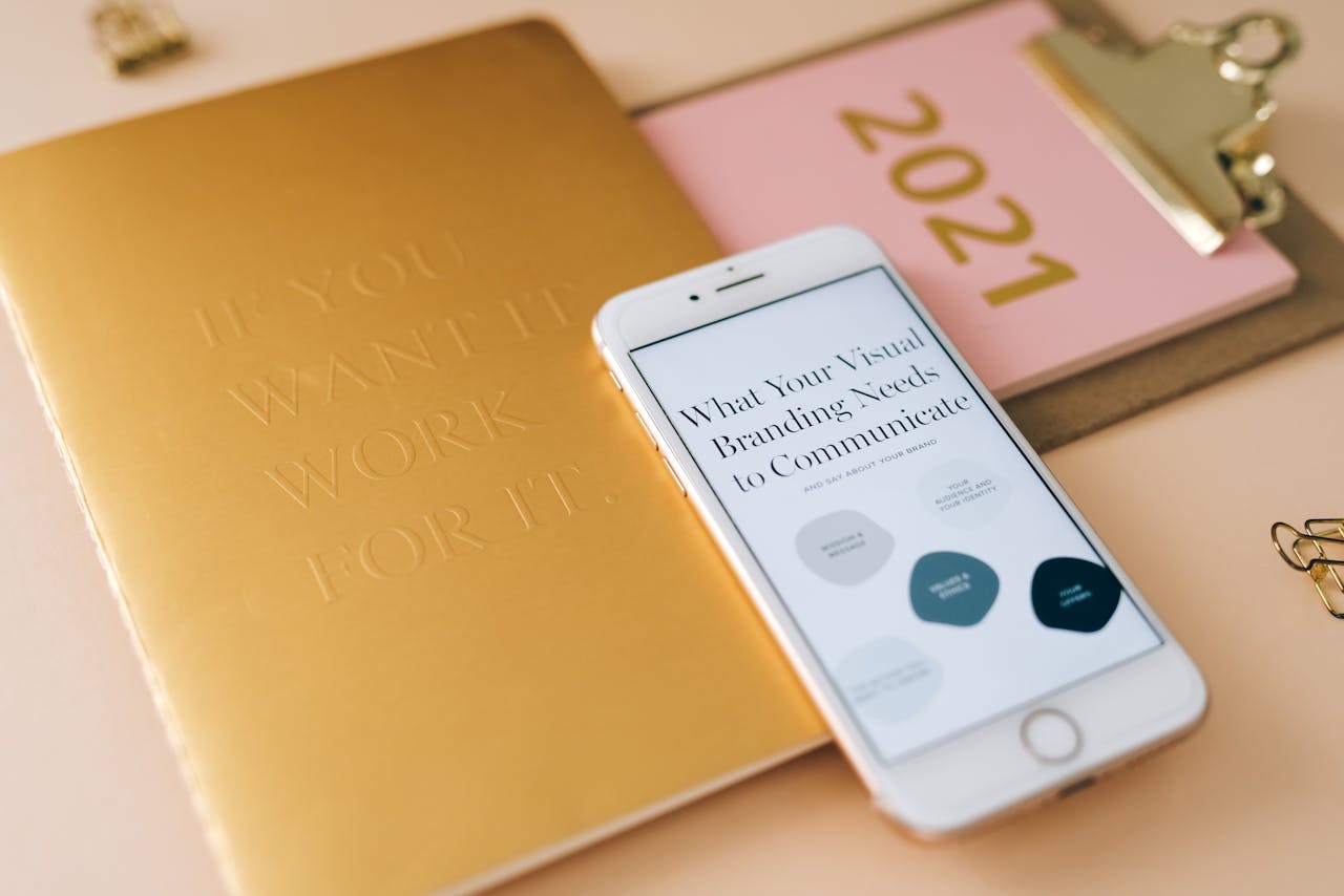 A smartphone and notebook on a desk for business planning and branding strategy.